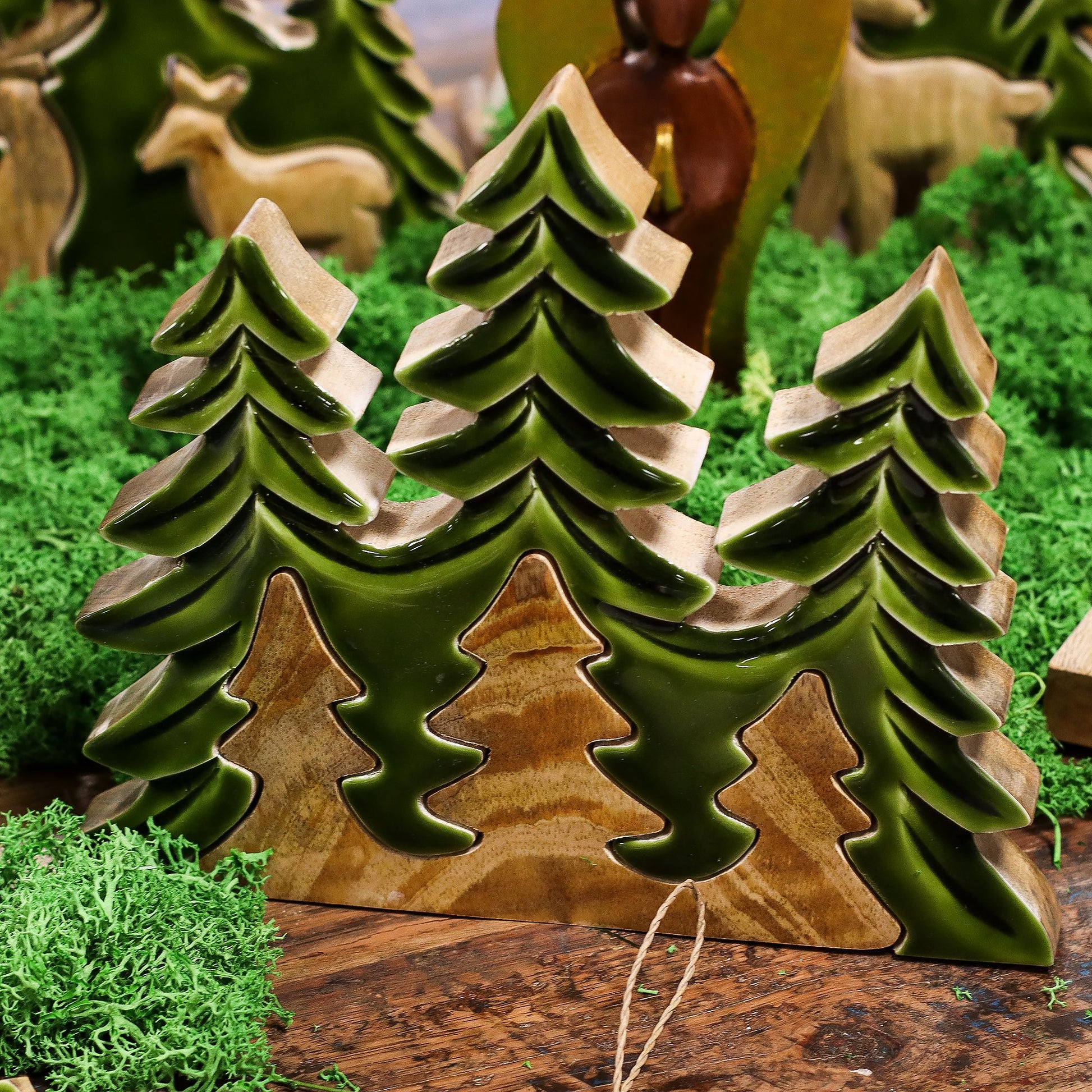 20×23cm 3D mango wood three pine trees decoration with deep green enamel branches on wooden base, styled on winter mantel with fairy lights and snow