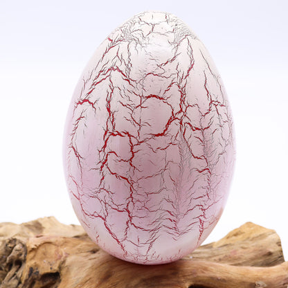 Vivid orange crackle egg shade glowing like molten fire atop twisted driftwood base