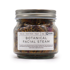 250g jar of dried lavender buds, rose petals, chamomile & calendula flowers spilling onto white marble with steaming bowl in soft spa setting