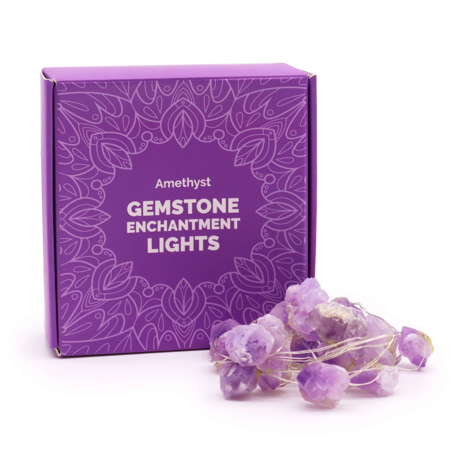 Amethyst crystal fairy lights glowing soft purple in glass vase on bedside table with candles and spiritual books in dreamy boho bedroom