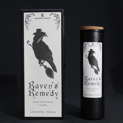 Black matte glass Raven’s Remedy candle burning with purple flame, surrounded by raven feathers, dried lavender, fennel seeds and a spell card on dark velvet
