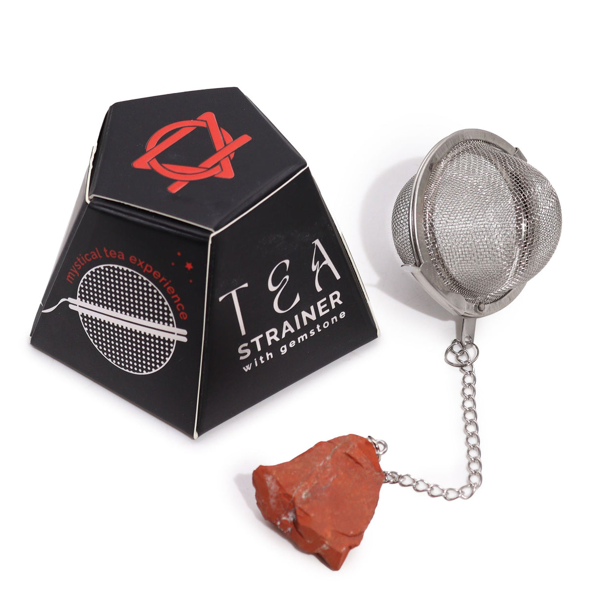 Tea strainer with gemstone next to its packaging on a white background
