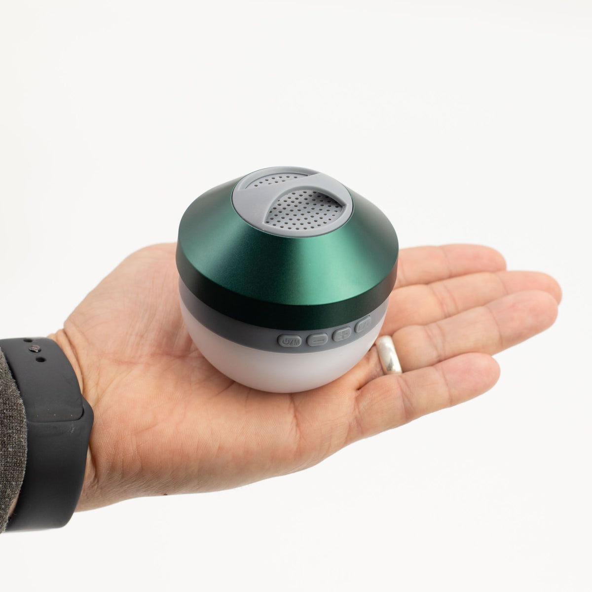 Speaker in hand demonstrating pocket-sized 170g portability and easy one-hand carry