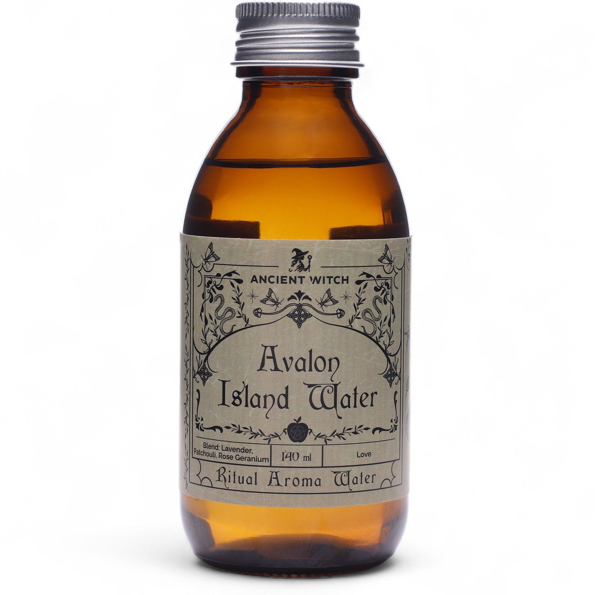 140ml amber bottle of Avalon Island ritual water with misty isle & nine priestesses label, surrounded by fresh lavender, roses and glowing candles