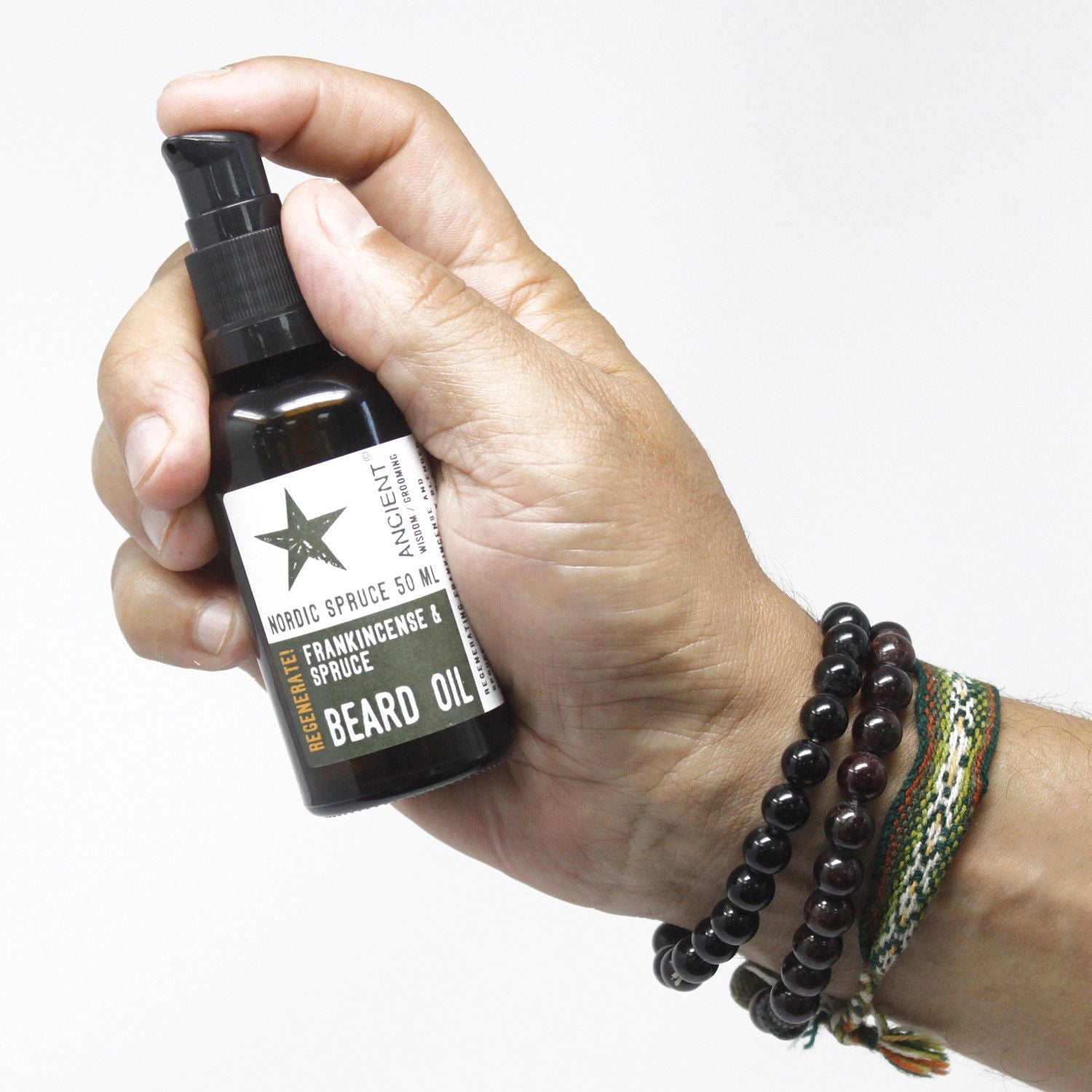 Hand holding a bottle of beard oil with a white background