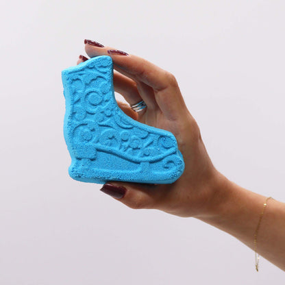 Hand holding a blue ice skate bath bomb