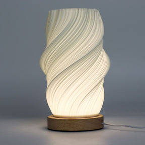 Close-up of lamp’s textured honeycomb pattern and soft diffused light, showing elegant cloud-like twisted shape and wooden base detail