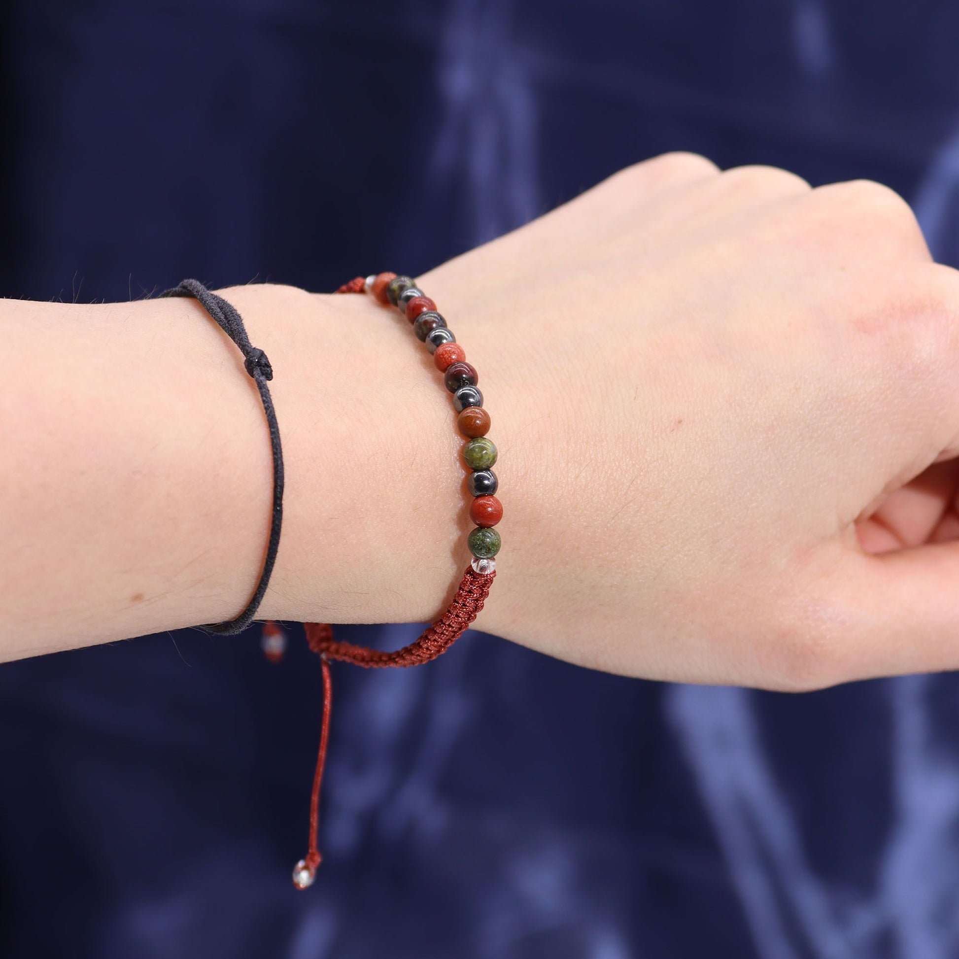 Close-up of a wrist wearing a red beaded bracelet