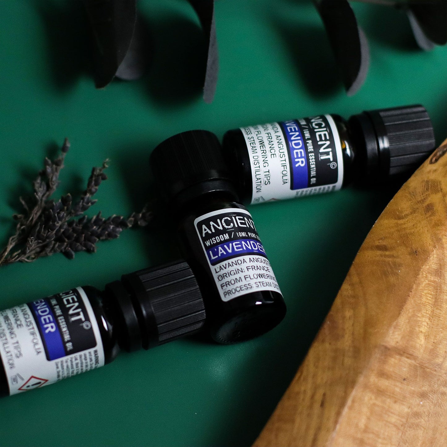 10ml amber glass bottle of pure Lavender Essential Oil with black dropper cap, fresh lavender sprigs