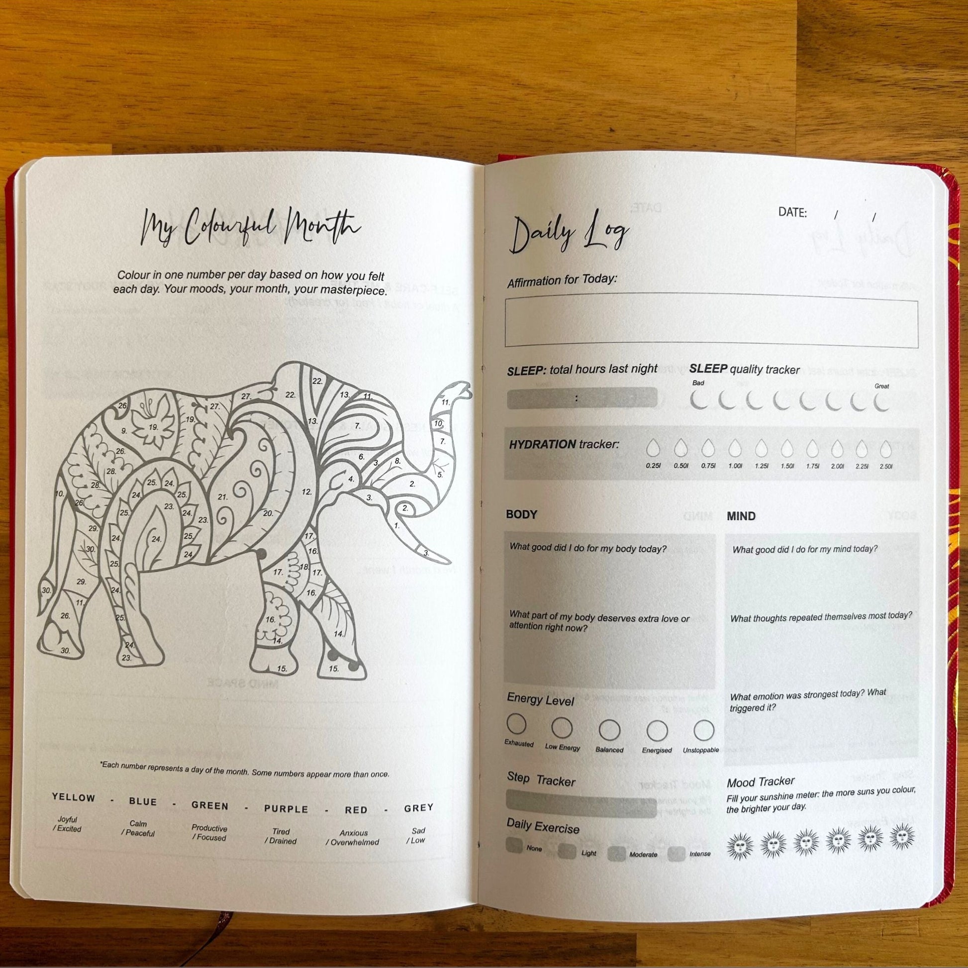 Elegant white wellness journal with rose gold foil Tree of Life, open to mood tracker and affirmation pages, styled with crystals, rose quartz and candle