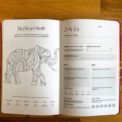 Elegant white wellness journal with rose gold foil Tree of Life, open to mood tracker and affirmation pages, styled with crystals, rose quartz and candle