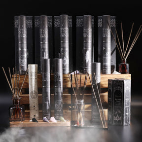 Collection of incense sticks and pendulum with packaging on a dark background
