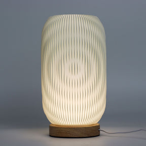 Close-up of lamp’s textured honeycomb pattern and soft diffused light, showing elegant twisted modern shape and wooden base detail