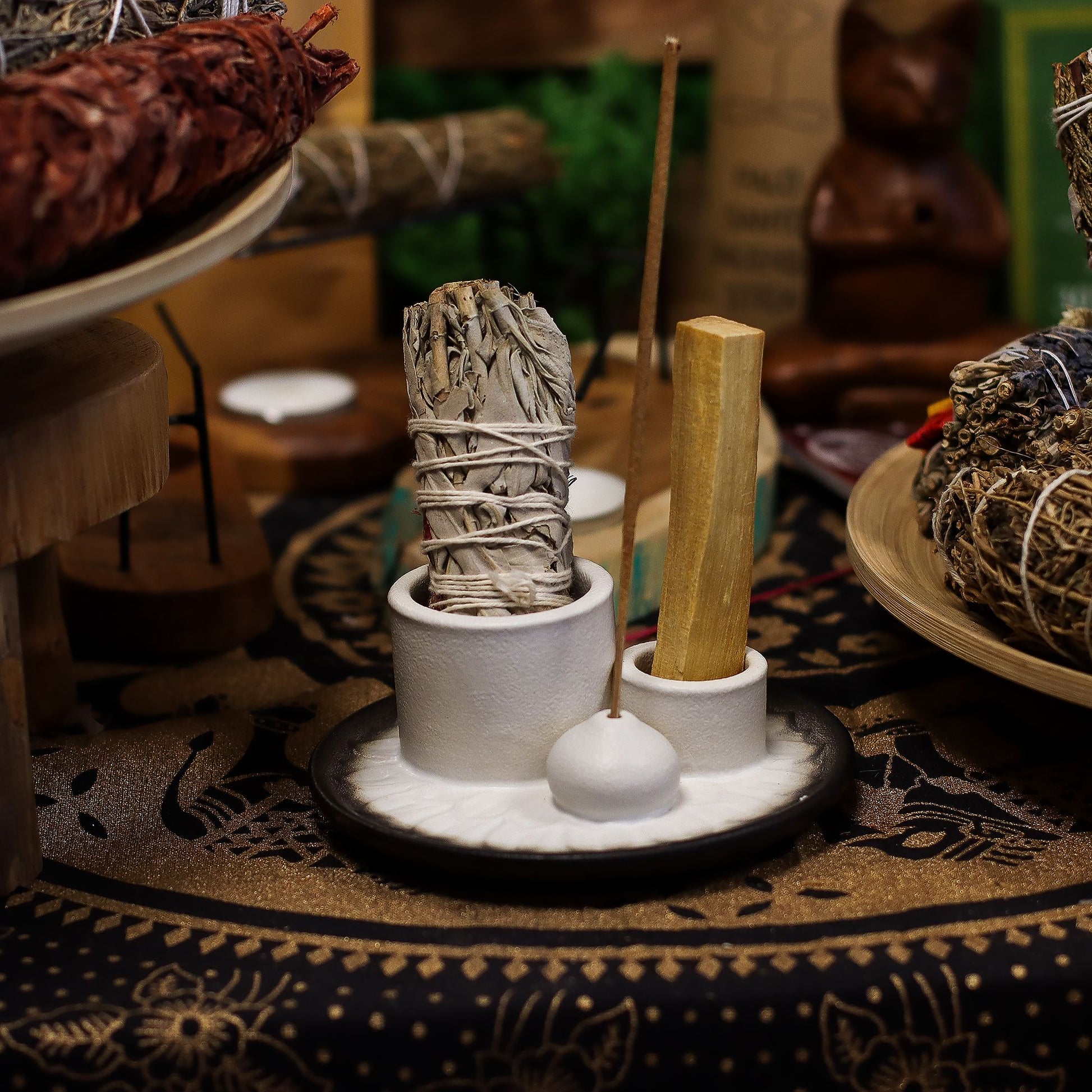 White & grey ceramic mandala smudge holder with Palo Santo stick burning, white sage bundle and incense stick, styled on neutral altar