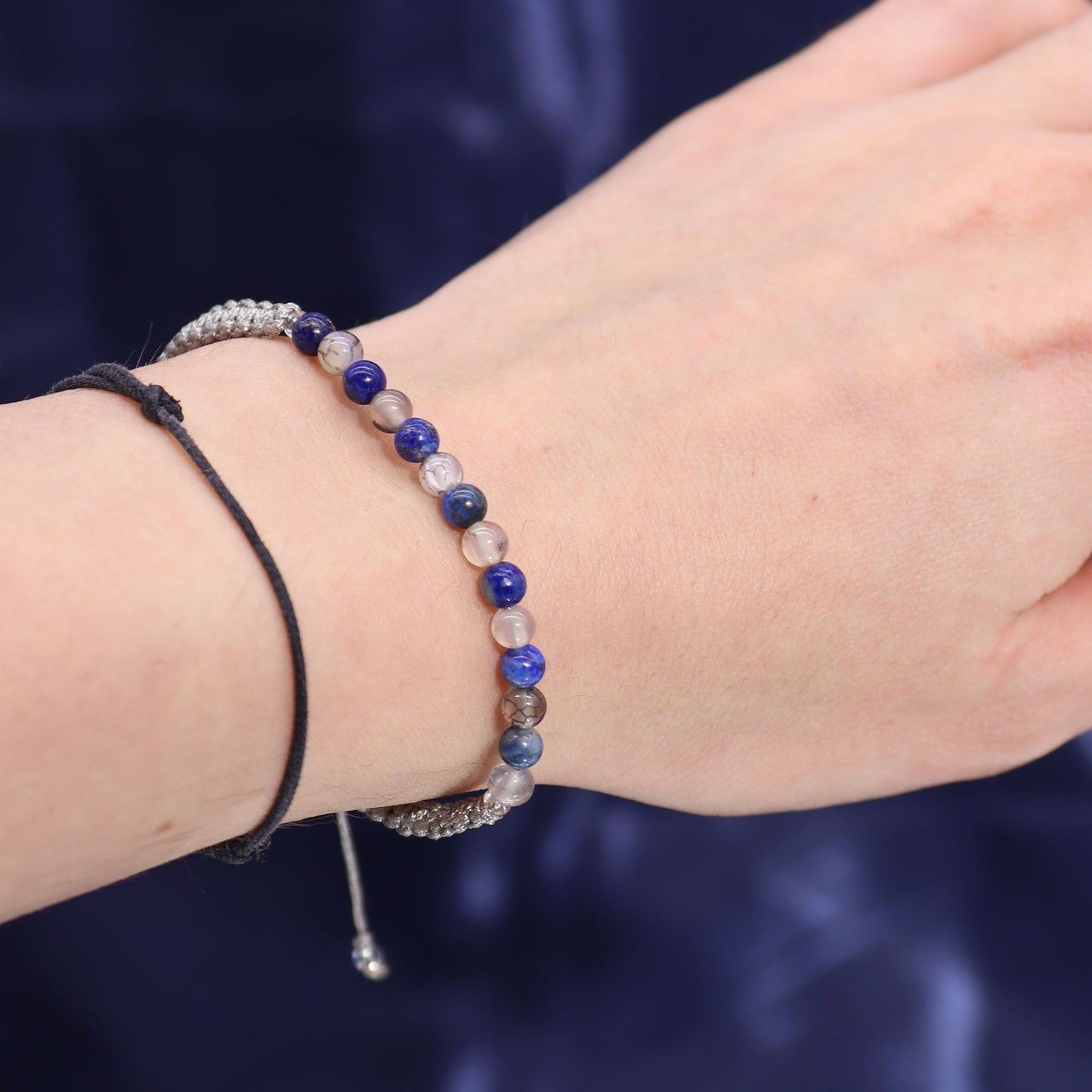 Close-up of a wrist wearing multiple bracelets