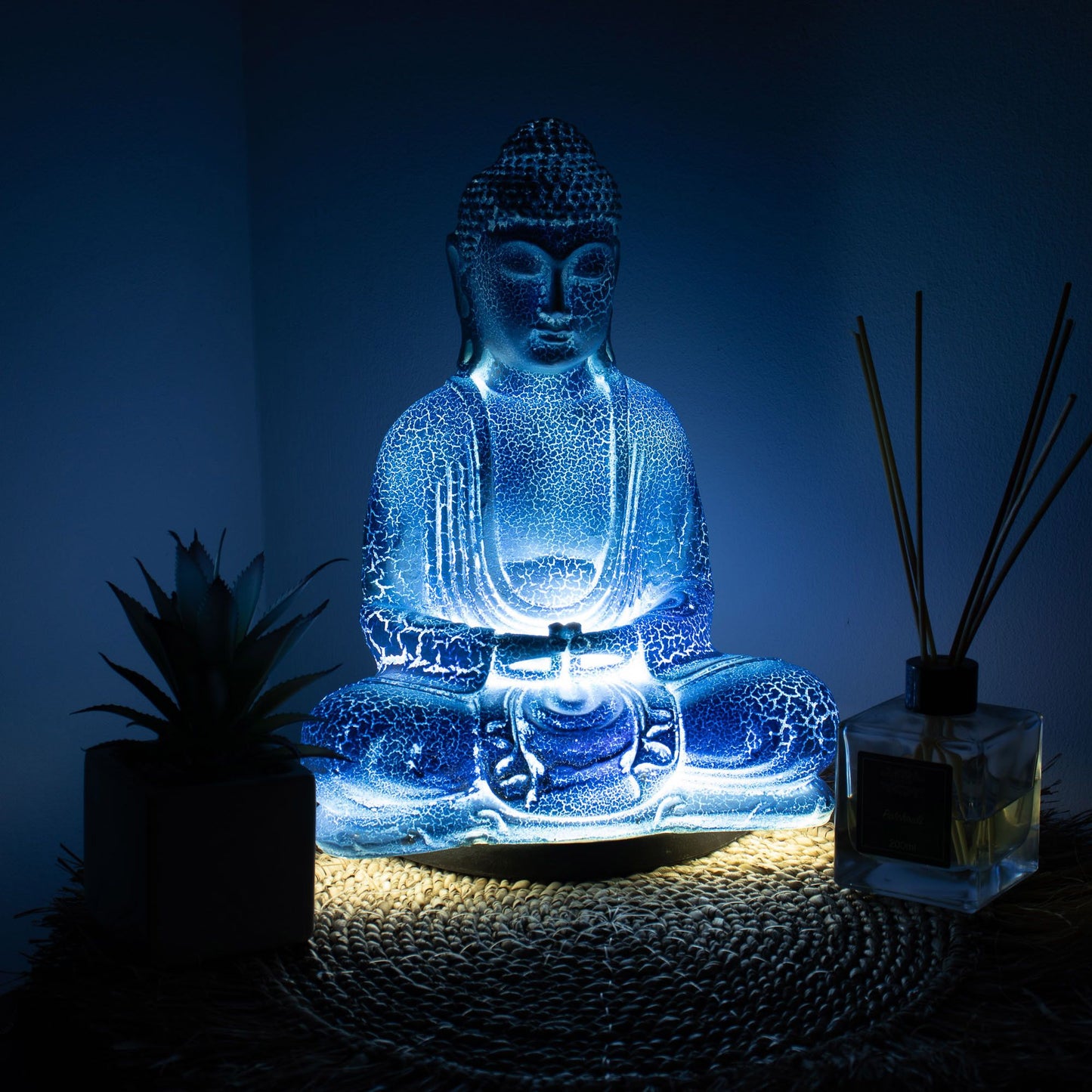 Meditation Buddha Lamp with crackle textured surface on modern oval stand, emitting soft warm ambient glow in a calm living space with subtle lighting