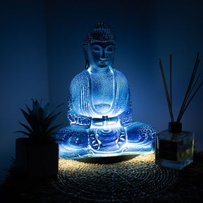 Meditation Buddha Lamp with crackle textured surface on modern oval stand, emitting soft warm ambient glow in a calm living space with subtle lighting