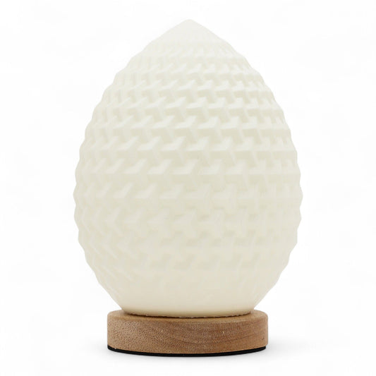 Teardrop New Wave USB lamp with textured honeycomb surface, warm glow on 3rd brightness setting, placed on wooden base