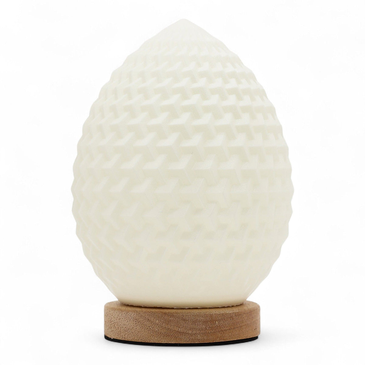 Teardrop New Wave USB lamp with textured honeycomb surface, warm glow on 3rd brightness setting, placed on wooden base
