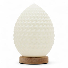 Teardrop New Wave USB lamp with textured honeycomb surface, warm glow on 3rd brightness setting, placed on wooden base
