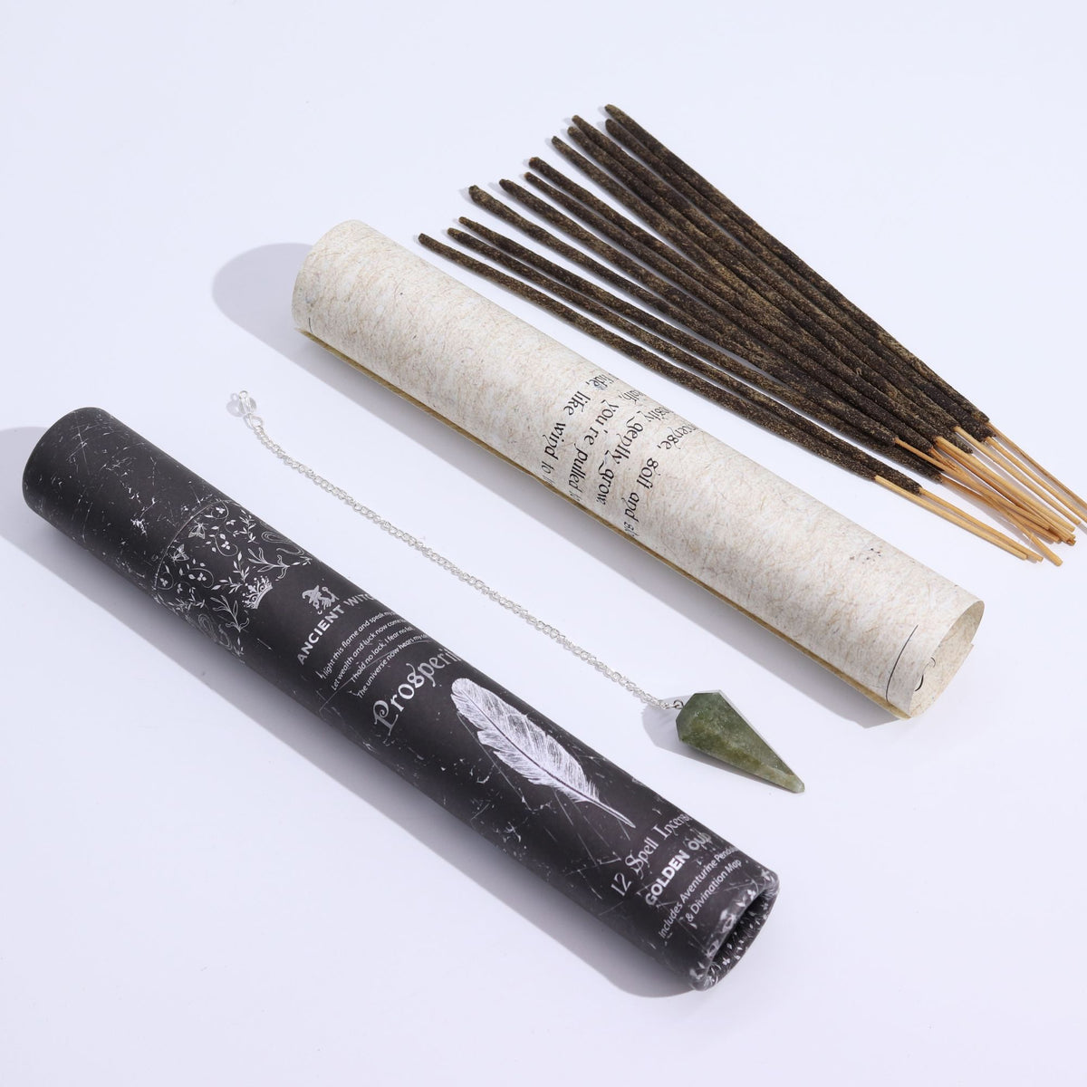 Incense sticks and pendulum with a black cylindrical container on a white background