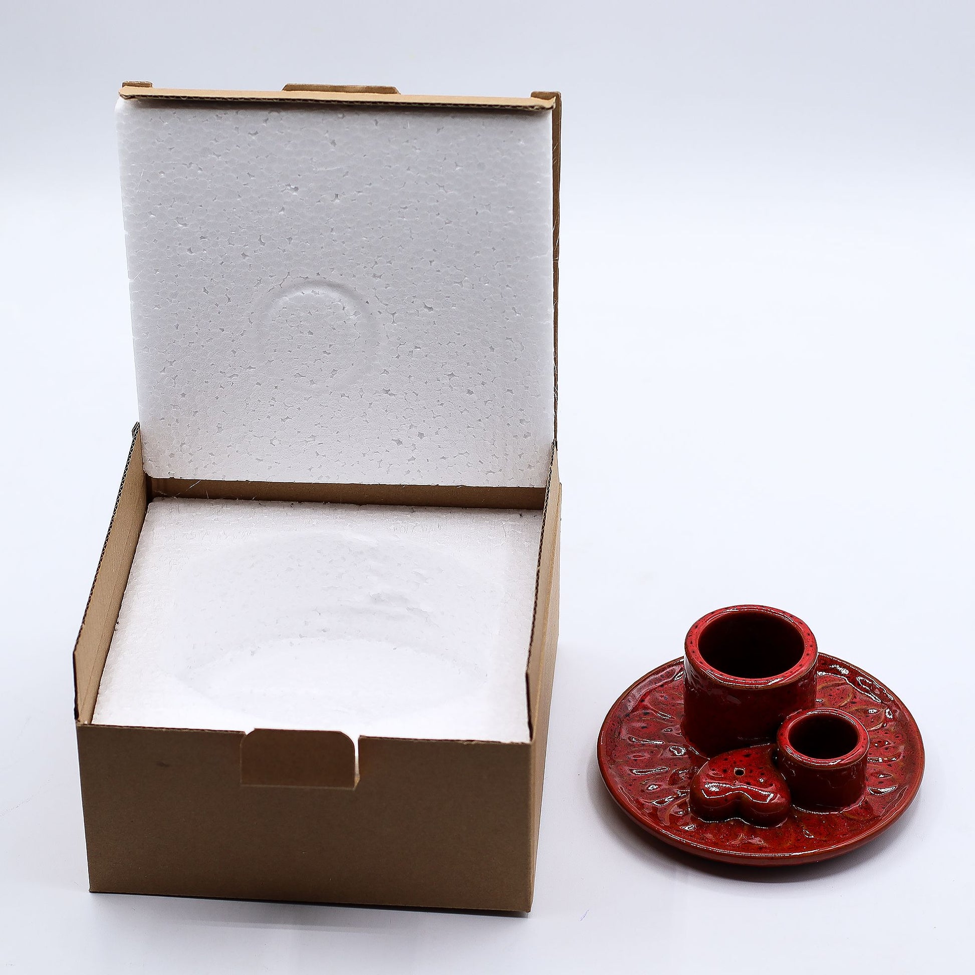 Red ceramic incense burner with a heart design on a white background