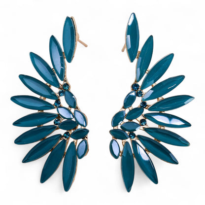 Teal green angel wing earrings with translucent vintage glass and silver stainless steel, hanging against forest backdrop with soft sunlight