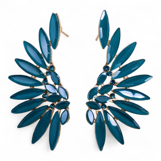 Teal green angel wing earrings with translucent vintage glass and silver stainless steel, hanging against forest backdrop with soft sunlight