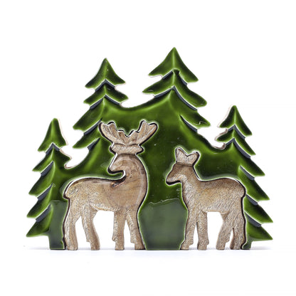 3D mango wood deer in forest decoration with two standing deer, green enamel trees and layered woodland scene on mantel with fairy lights and pine cones