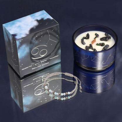 Blue candle with star design, packaging, and bracelet on a reflective surface