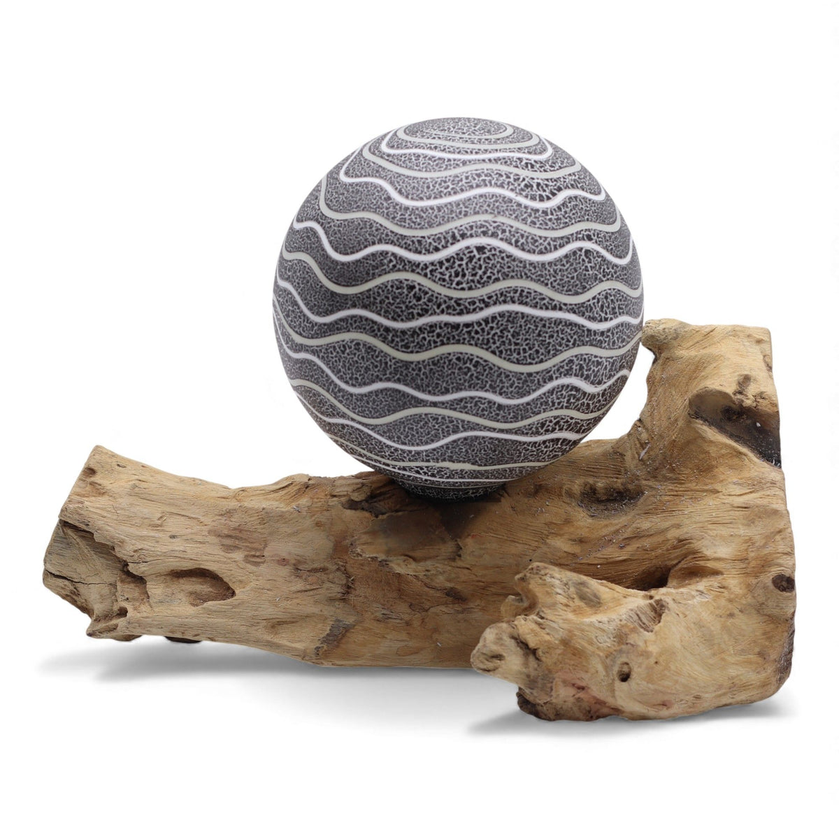 Grey Luna textured sphere glowing softly atop twisted driftwood base
