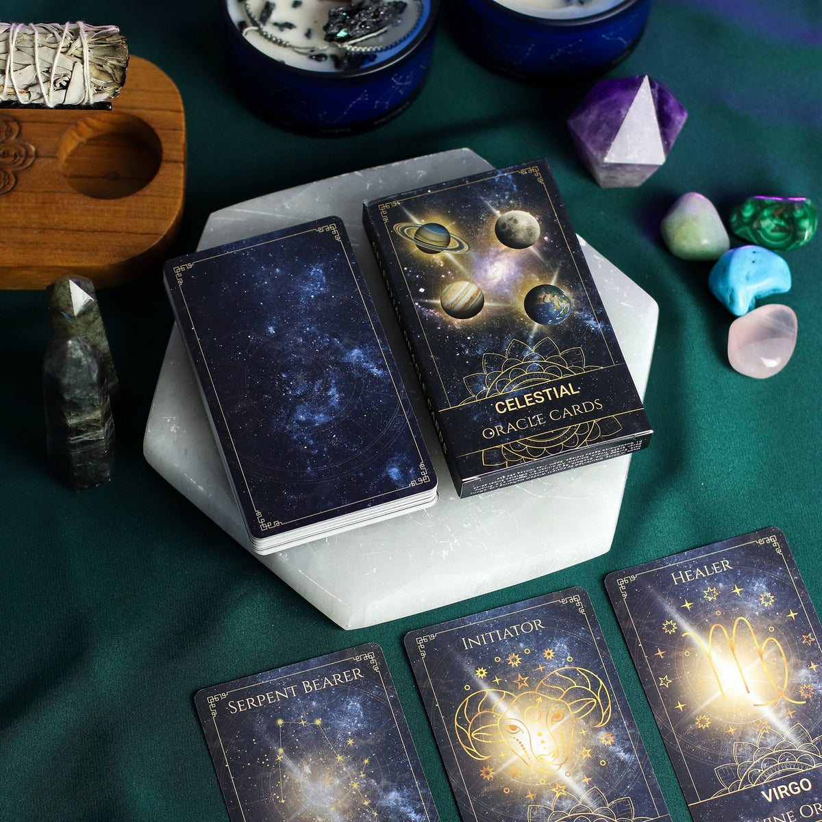 Celestial Energy Atlas Oracle Deck fanned out showing midnight blue cards with golden planets, stars & zodiac symbols, box with cosmic design on starry background