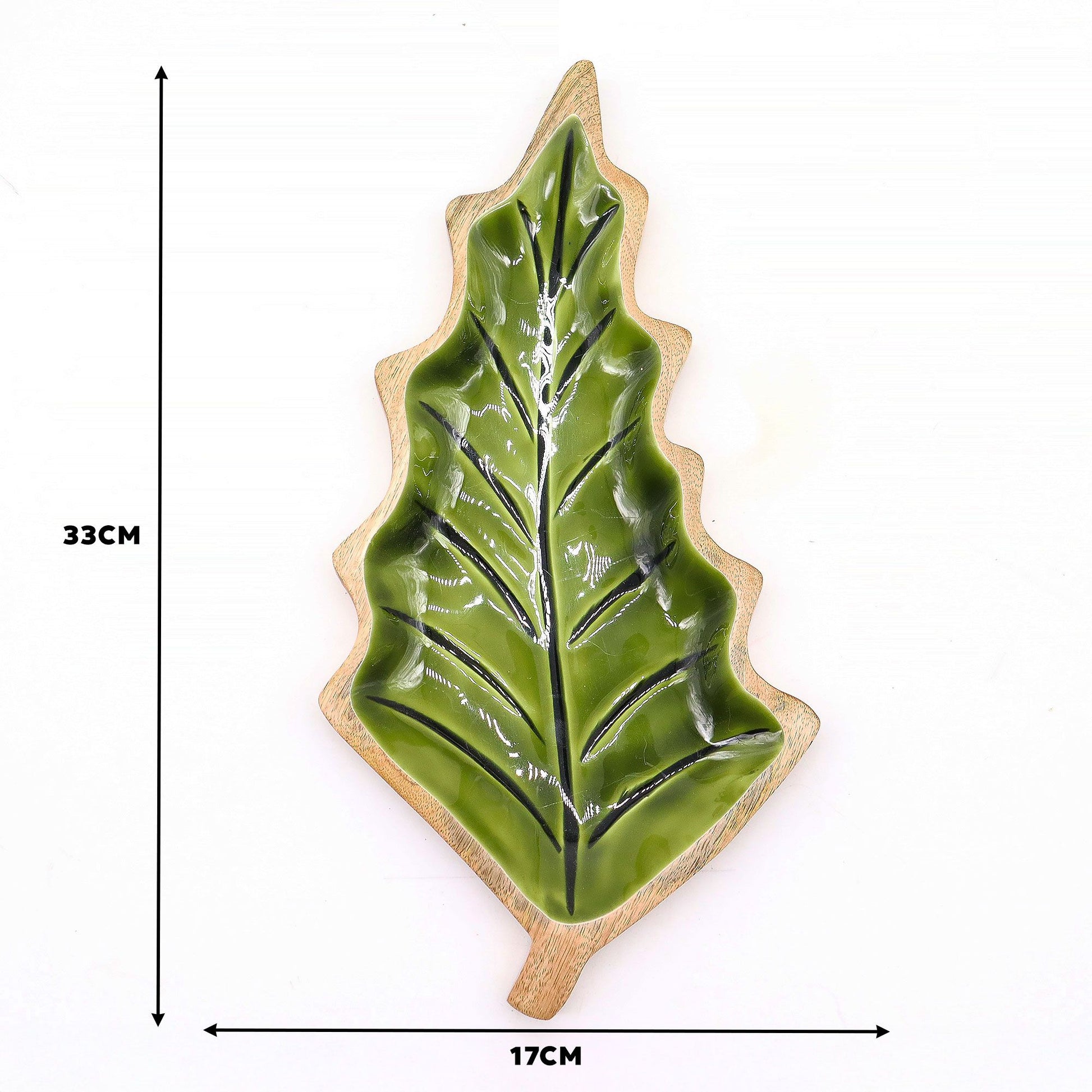 Large leaf-shaped mango wood bowl with rich green enamel inside, filled with pine cones and candles on autumn table setting