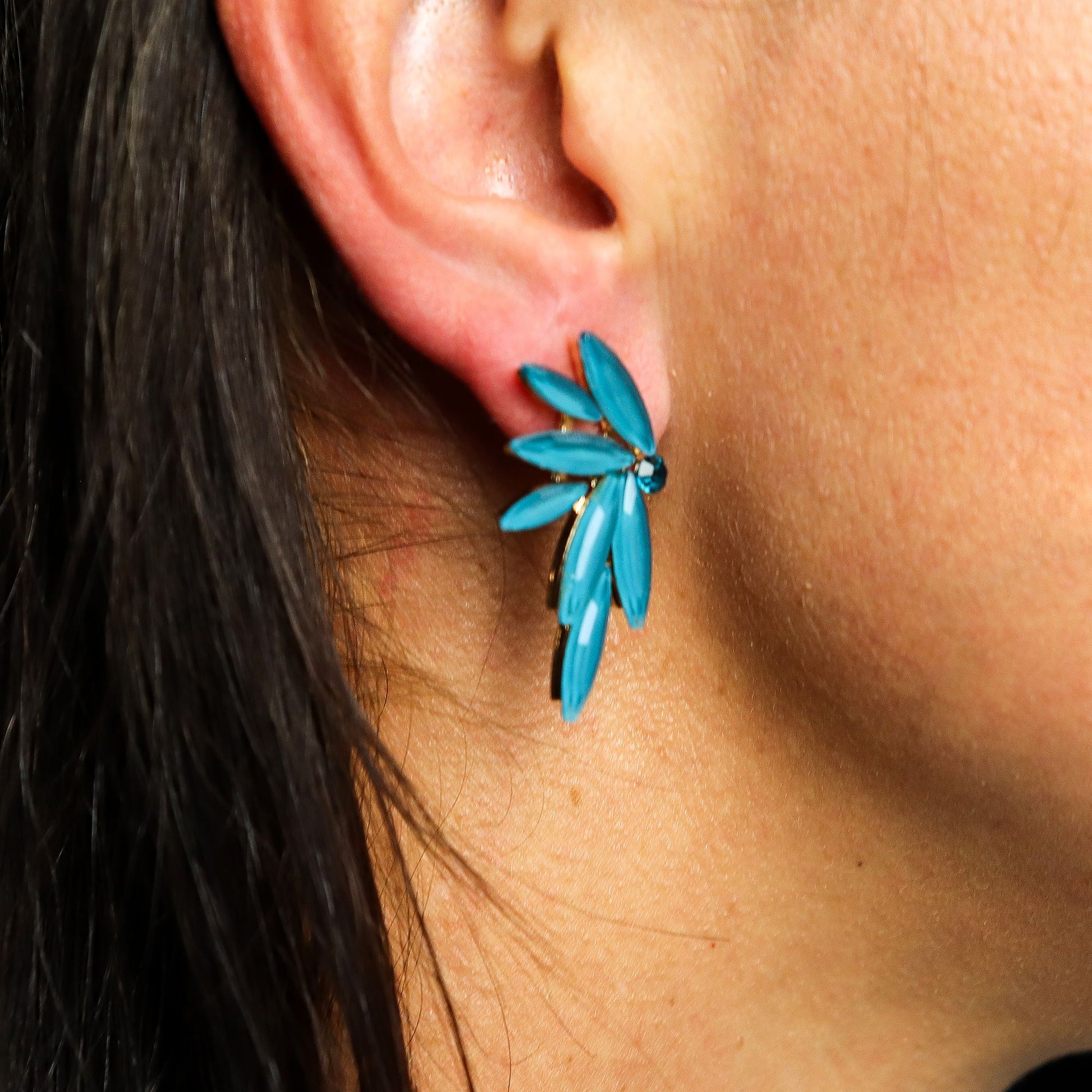 Delicate teal-green fairy wing earrings with translucent vintage glass, glowing softly against moss and forest leaves