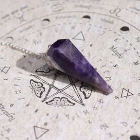 Amethyst crystal pendulum on an astrological chart