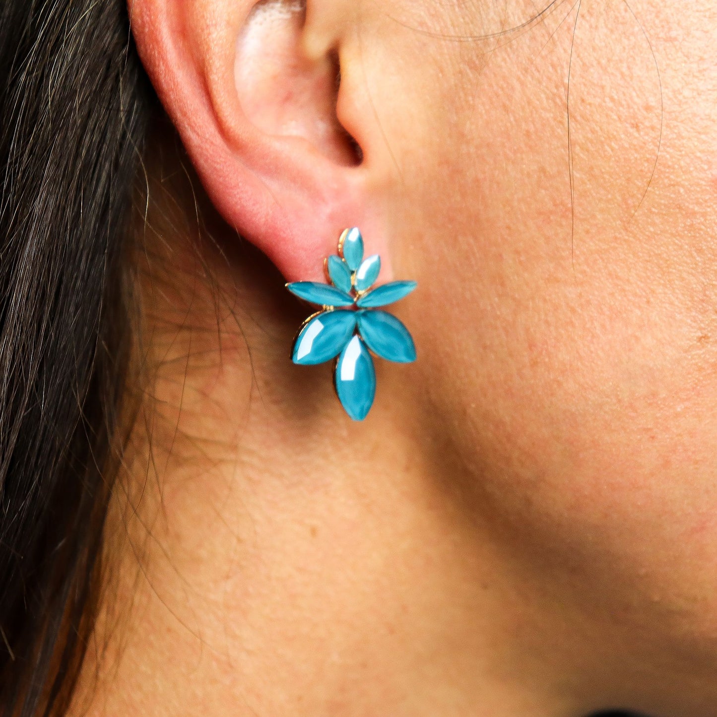 Teal green vintage glass flower earrings glowing like fresh spring leaves, styled on white linen with moss and tiny forest flowers