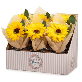 Bouquets of yellow soap sunflowers in brown paper packaging inside a decorative box with 'SOAP & FLORAL' branding.
