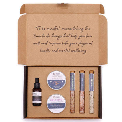 Mindful Moments Self Care Kit in elegant gift box open to reveal coffee sugar scrub jar, body cream, three bath salt vials, hyaluronic acid serum dropper bottle, fresh coffee beans and lavender on marble