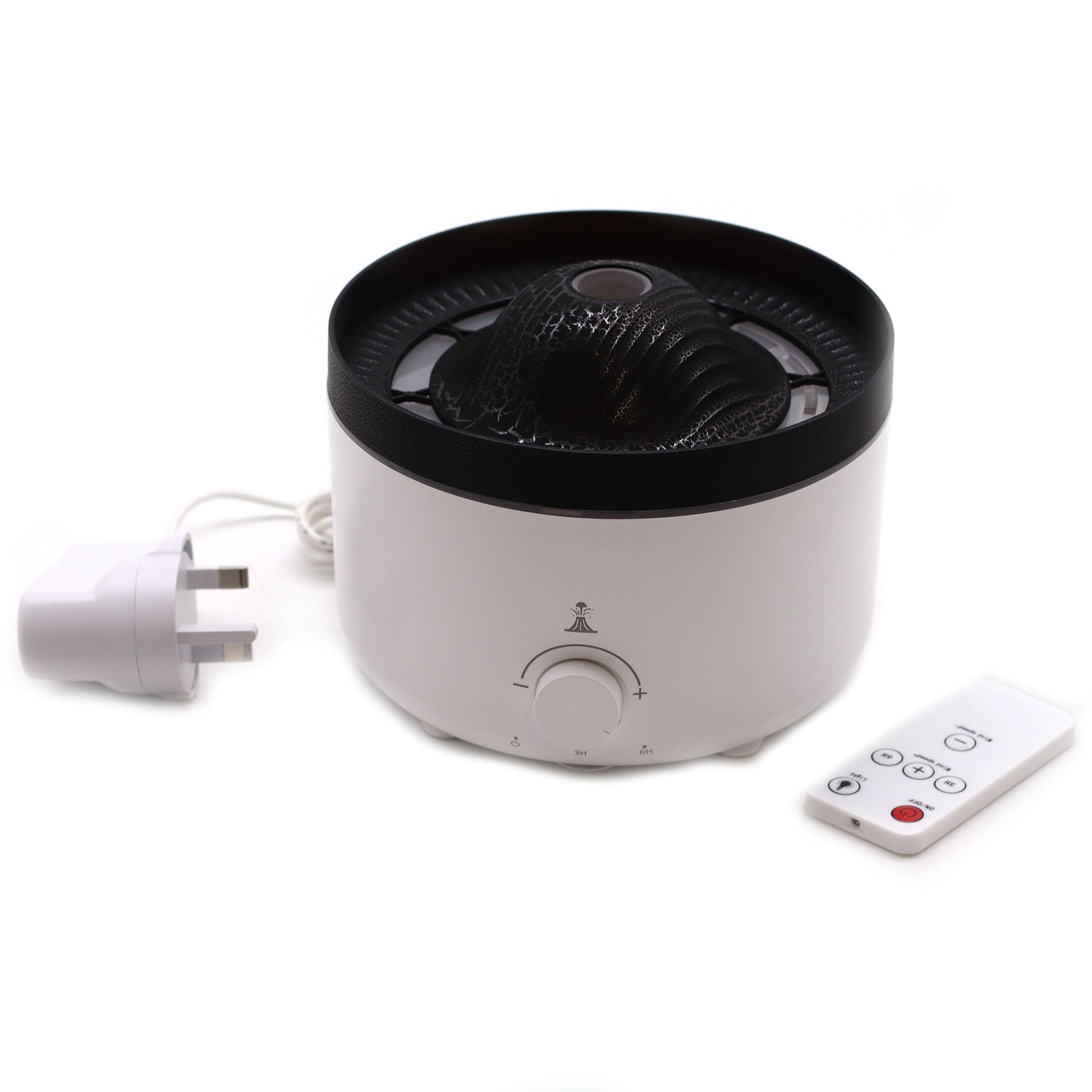 Large black volcano aroma diffuser erupting with swirling coloured mist and glowing LED ring, essential oil bottle beside