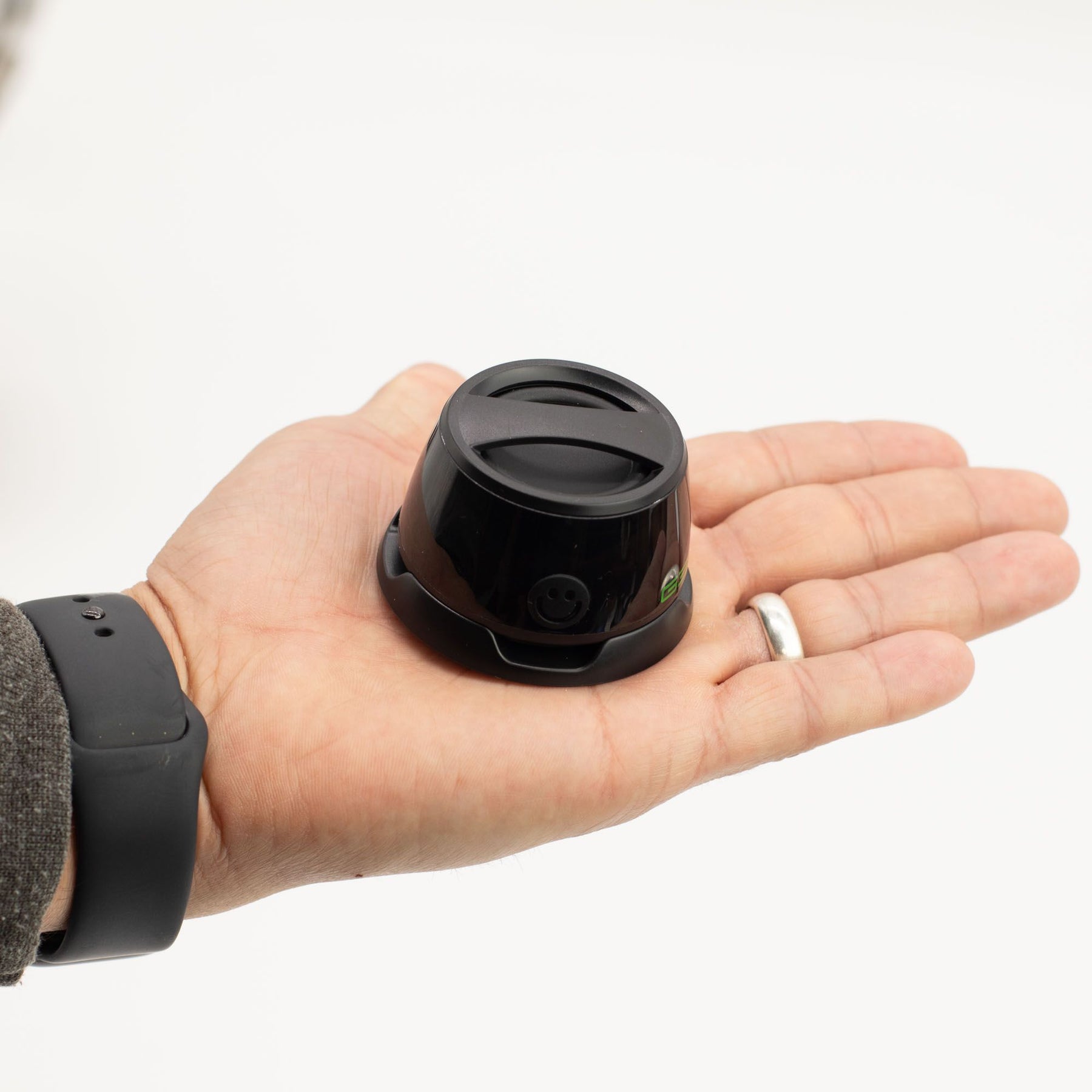 Hand holding a G300 mini speaker on a white background