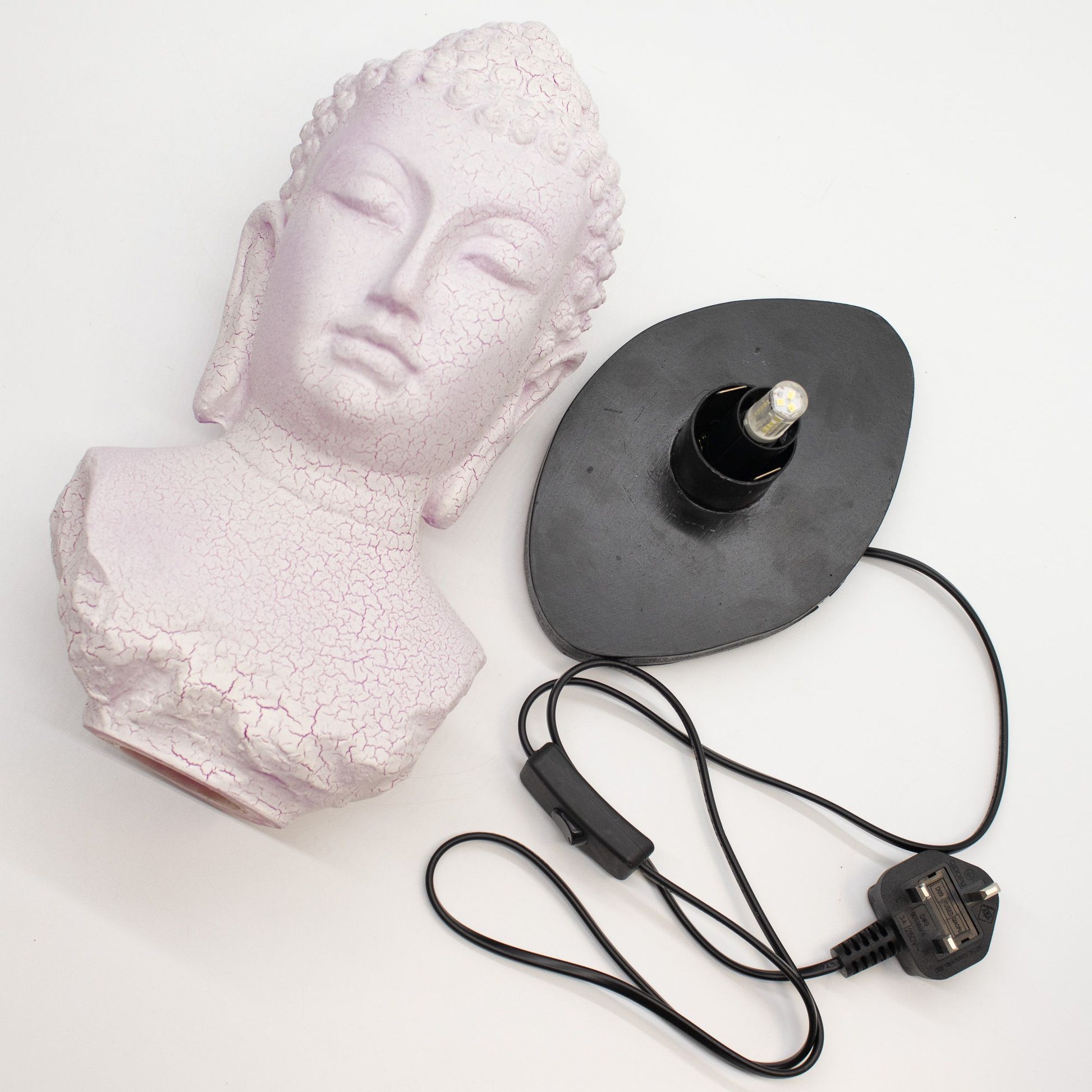 Buddha Bust Lamp with crackle textured surface on modern oval stand with cord on a white background