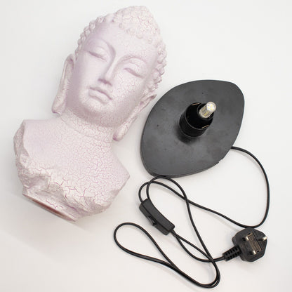Buddha Bust Lamp with crackle textured surface on modern oval stand with cord on a white background