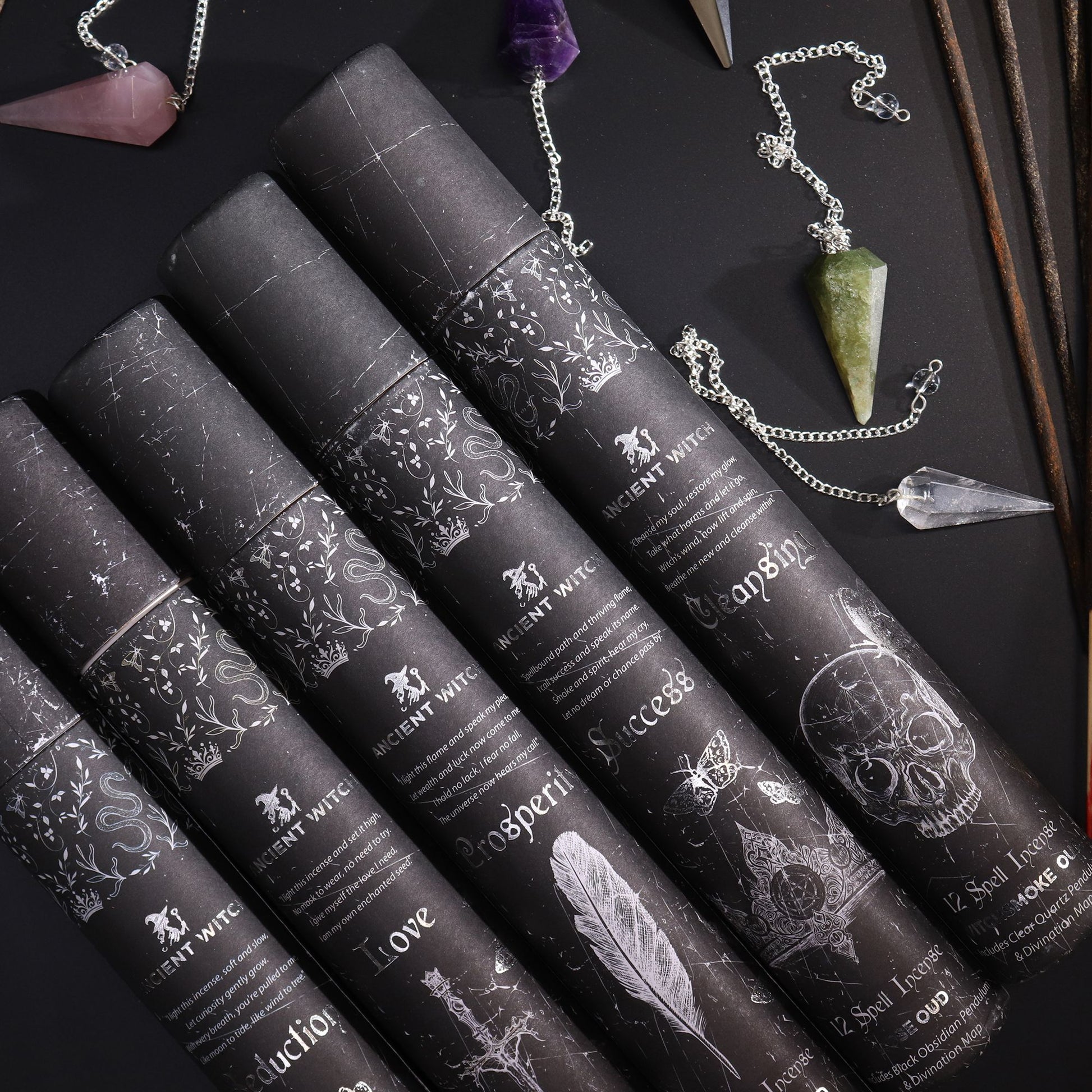 Set of black cylindrical containers with decorative labels on a dark surface with pendulum.